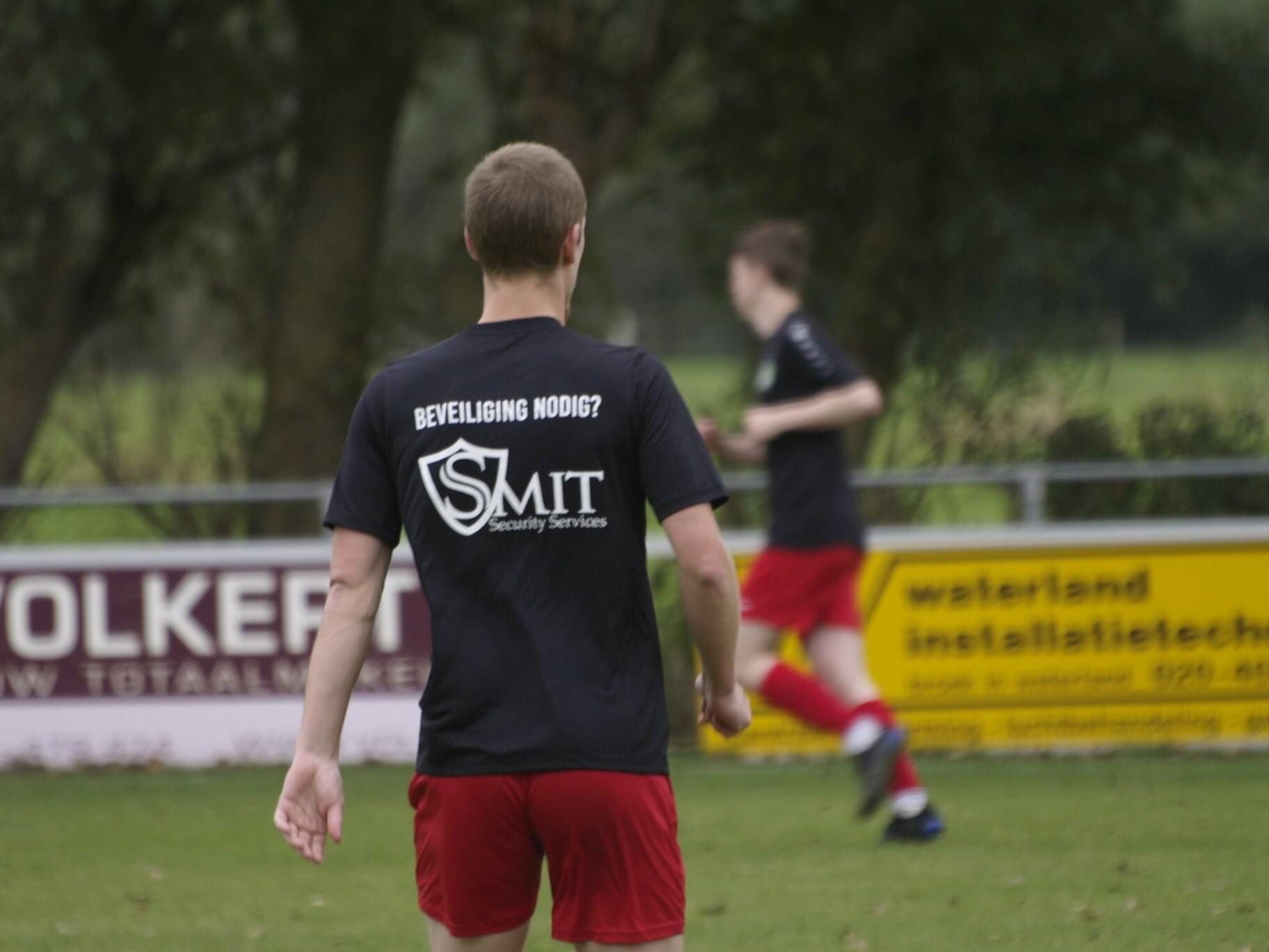 Voetbalspeler loopt en draagt logo met shirt van Smit Security Services