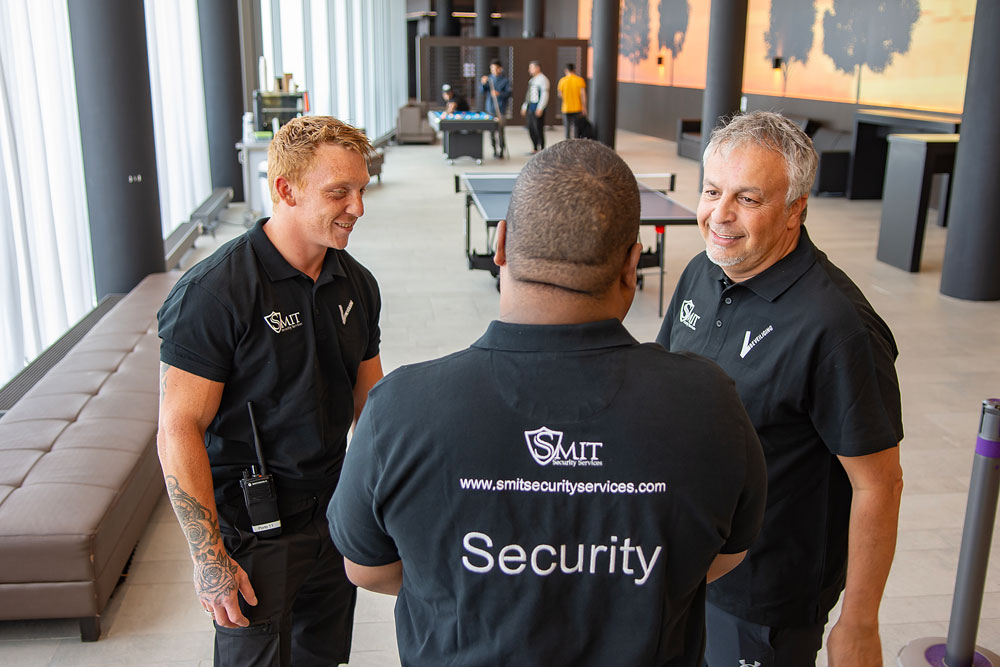 Overleg tussen beveiligers van Smit Security in een hotel lobby