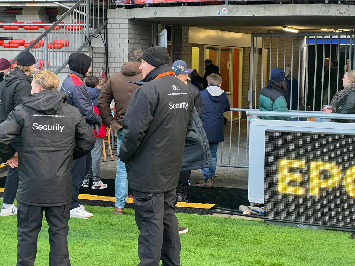 Twee eveiligers van Smit Security Services houden toezicht tijdens een Rugby wedstrijd